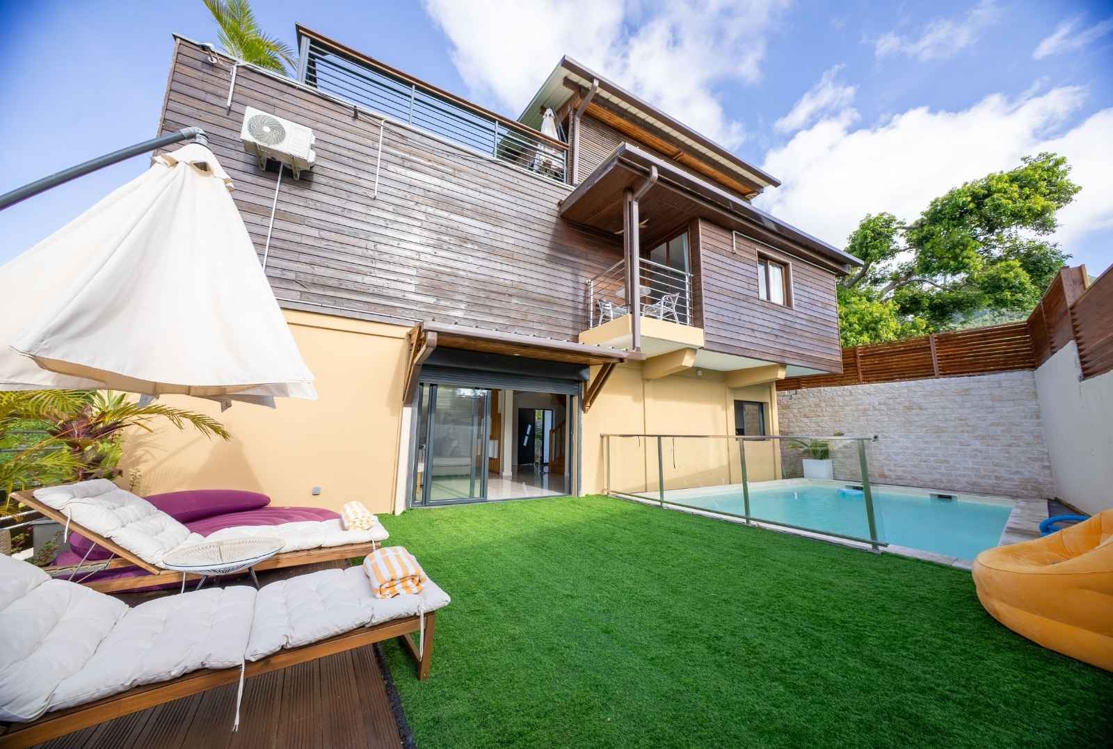 Extérieur de la villa avec piscine, transats et coin détente – Résidence Kazela, idéale pour les vacances à Mayotte